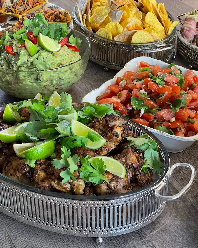 Serveeritud cateringi laud grillitud liha, salsa ja guacamole’iga