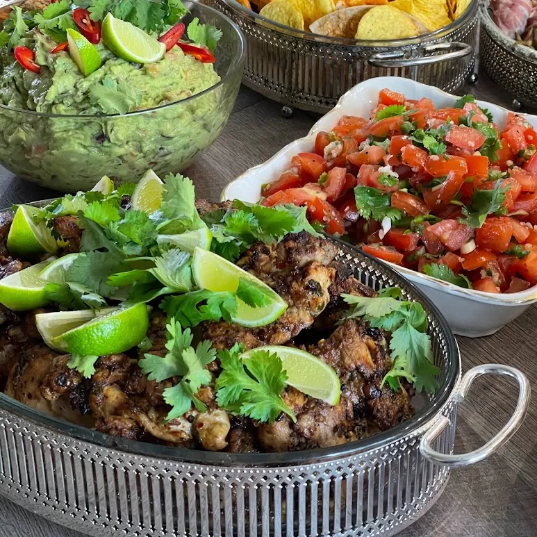 Serveeritud cateringi laud grillitud liha, salsa ja guacamole’iga